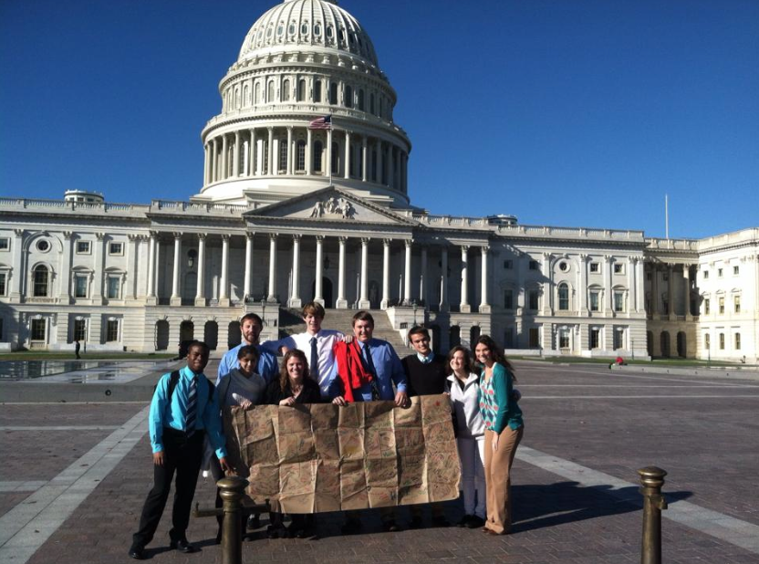 The group of students and teachers who traveled to Washington D.C. standing outside the National Capital holding a banner signed by the entire Girls Division. 