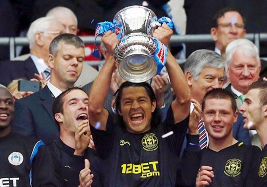 Roger Espinoza raises the FA Cup after Wigan Athletic stuns Manchester City in a 1-0 victory.