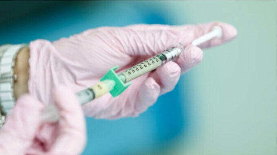A medical professional handles a vaccine (Qapta)
