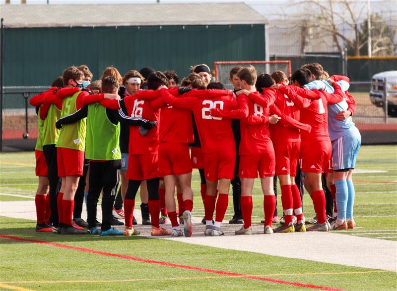 Regis Jesuit Varsity boys soccer team plays a home game against Douglas County on April 14, huddling to discuss strategies. 